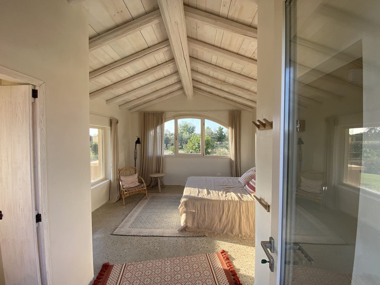 Schlafzimmer unter dem Holzdach mit Blick in den Garten